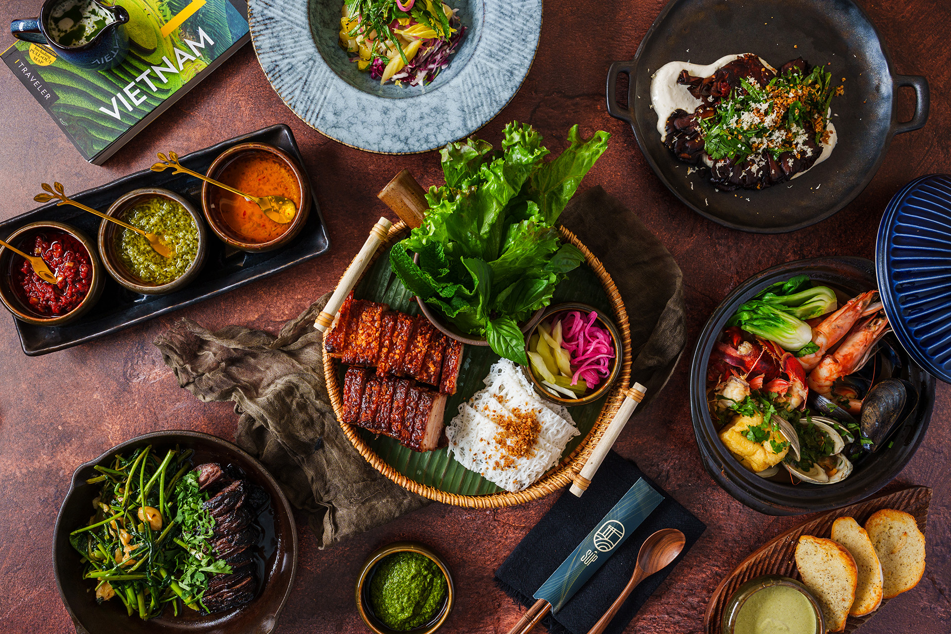 A Vietnamese feast with grilled dishes, herbs, noodles, and sauces